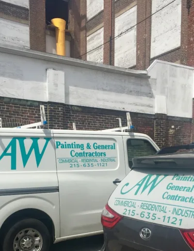 AW Painting & General Contractors, Inc. vehicles parked near a commercial building.